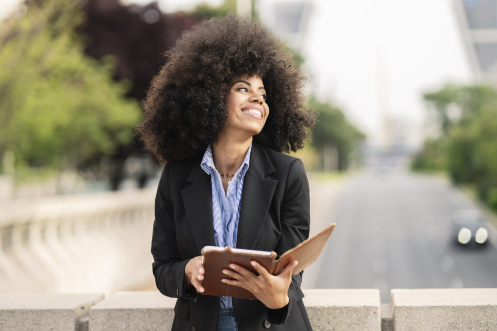 afro american woman reading a book in the city -digital book concept-